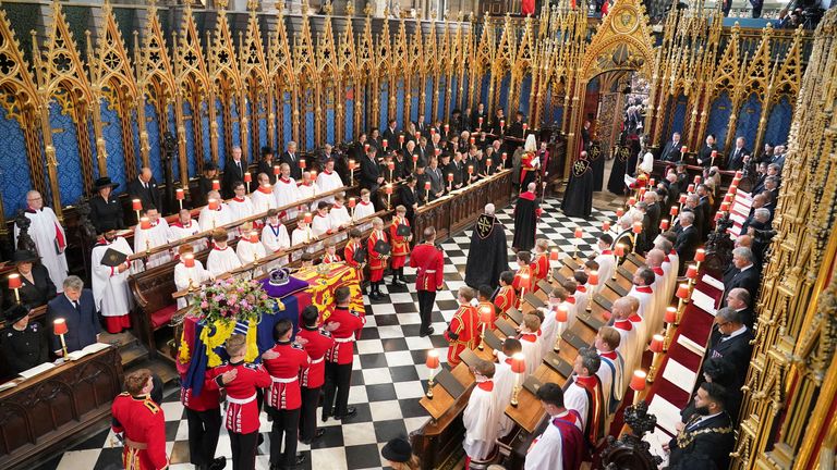 The coffin of Queen Elizabeth II, draped in the Royal Standard with the Imperial State Crown and the Sovereign&#39;s Orb and Sceptre, is carried from her State Funeral at Westminster Abbey in London. Picture date: Monday September 19, 2022. Dominic Lipinski/Pool via REUTERS