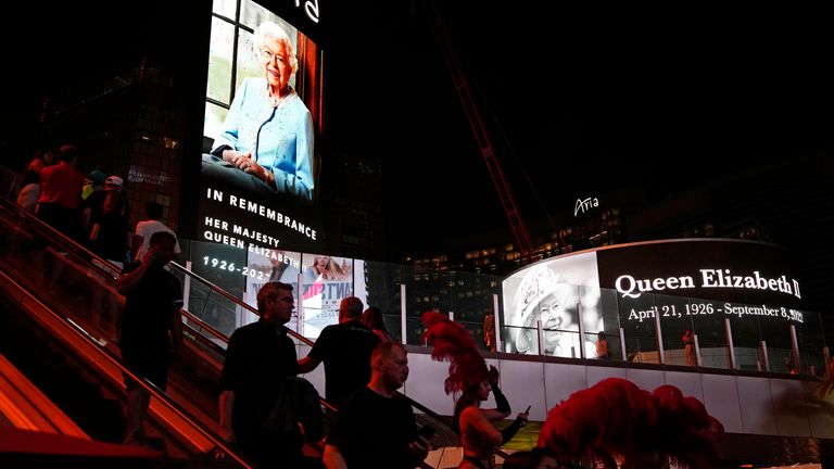 People travel along the Las Vegas Strip as images of Queen Elizabeth II are shown on casino advertising hoardings. Pic: AP