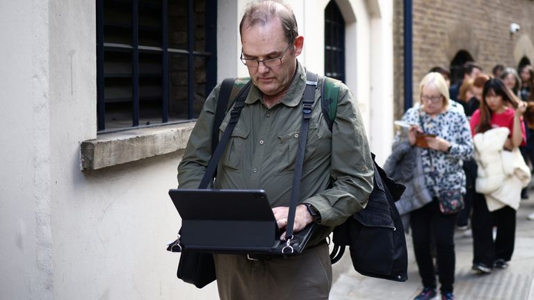 Stuart Murphy works on his iPad as he stands in a queue near Bermondsey to pay his respects, following the death of Britain&#39;s Queen Elizabeth, in London, Britain, September 15, 2022. REUTERS/Henry Nicholls