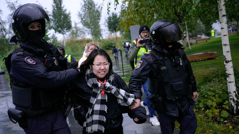 Polis memurları, 24 Eylül 2022 Cumartesi, Moskova, Rusya'daki kısmi seferberliğe karşı bir protesto sırasında bir göstericiyi gözaltına aldı. (AP Photo)
