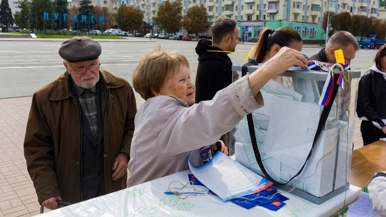 A woman casts her ballot during a referendum in Luhansk, Luhansk People&#39;s Republic controlled by Russia-backed separatists, eastern Ukraine, Saturday, Sept. 24, 2022. Voting began Friday in four Moscow-held regions of Ukraine on referendums to become part of Russia. (AP Photo)