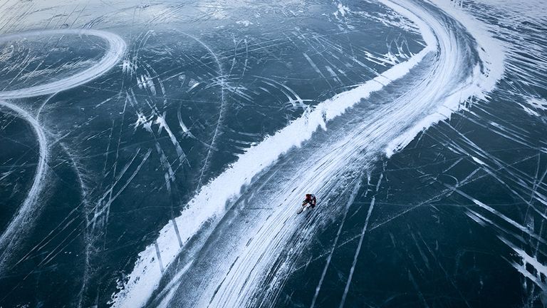 Siena Awards: Drone Photo Awards 2022. SPORT: Commended- Frozen Motorcycle Track by Bryan Helm A lone racer runs down a slippery runway.  Taken one late afternoon, over the frozen Ghost Lake.  Trails left behind by motorcycles create winding patterns and shapes on the ice.