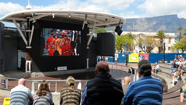 Orang-orang menyaksikan pemakaman Ratu Elizabeth II dari Inggris di layar lebar di Cape Town, Waterfront Afrika Selatan, Senin, 19 September 2022. (AP Photo/Nardus Engelbrecht)