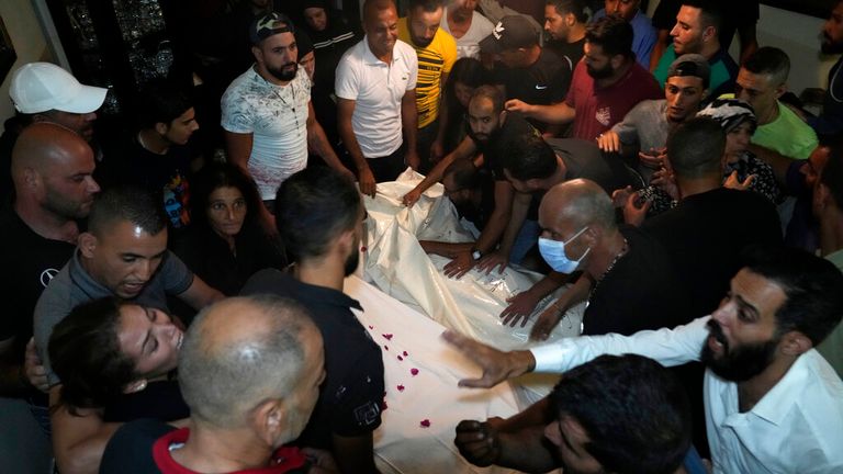 Mourners gather around two victims brought back to Tripoli, northern Lebanon. Pic: AP
