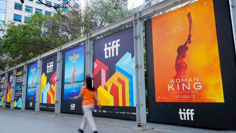 A pedestrian walks past posters of films being shown at the 2022 Toronto International Film Festival, Thursday, Sept. 8, 2022, on day one of the festival in Toronto. The 47th annual film festival runs through Sept. 18. (AP Photo/Chris Pizzello)