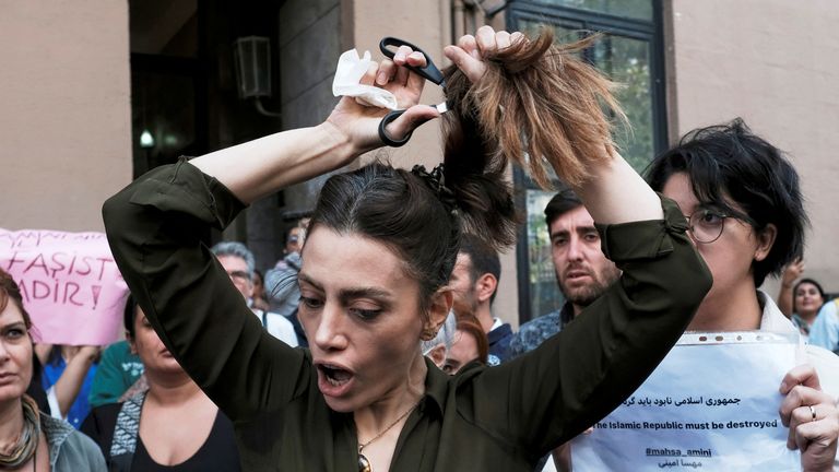 2022 年 9 月 21 日、トルコのイスタンブールにあるイラン領事館の外で、マーサ アミニの死を受けて抗議活動中に髪を切る、トルコに住むイラン人女性ナシーブ サムセイ。REUTERS/Morad Sezer