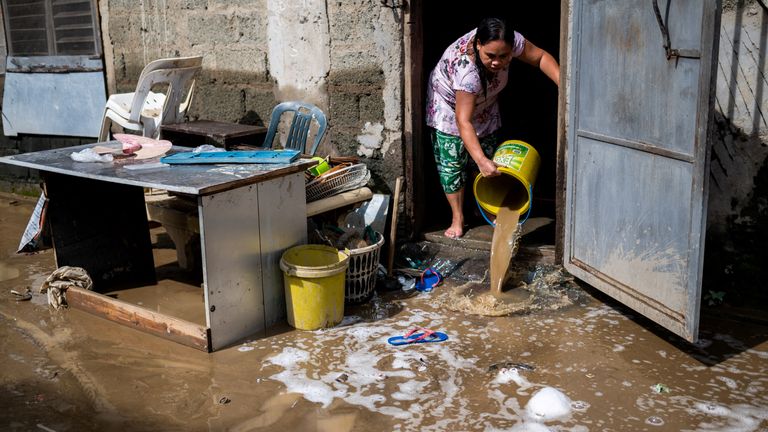 A woman clears her home from mud