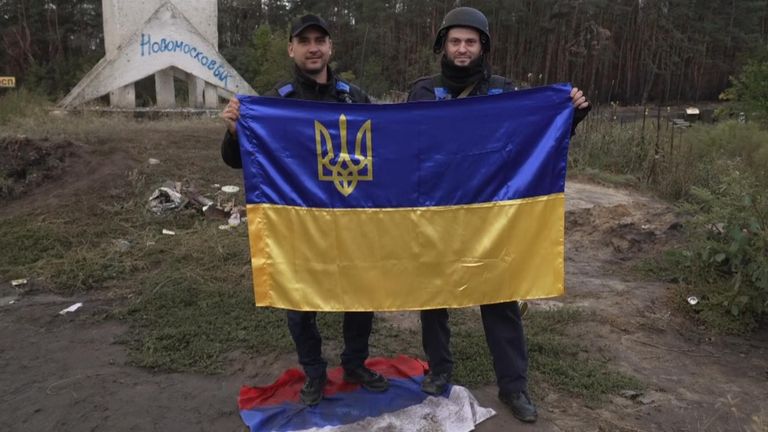 Ukraynalı askerler Inzyum'da bayrak tutuyor