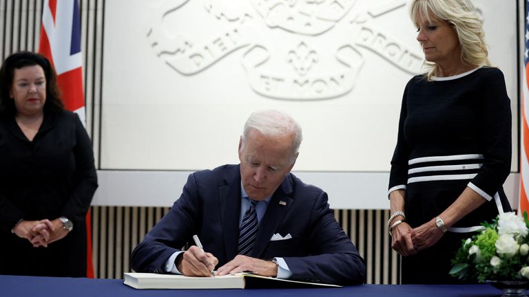 US President Joe Biden signs a condolence book as U.S. first lady Jill Biden looks on at the British Embassy, in Washington