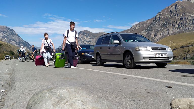 People walk toward the border crossing at Verkhny Lars between Georgia and Russia leaving Chmi, North Ossetia - Alania Republic, Russia, Thursday, Sept. 29, 2022. Long lines of vehicles have formed at a border crossing between Russia&#39;s North Ossetia region and Georgia after Moscow announced a partial military mobilization. A day after President Vladimir Putin ordered a partial mobilization to bolster his troops in Ukraine, many Russians are leaving their homes. (AP Photo)