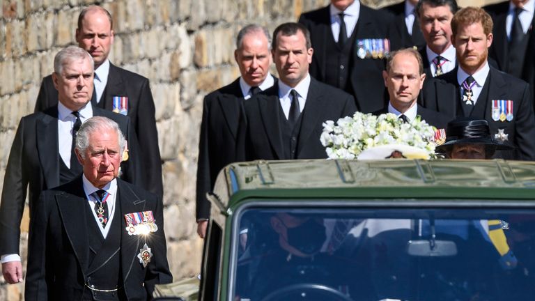 Britain's Prince Charles, from front left behind coffin, Princess Anne, obscured, Prince Andrew, Prince Edward, Prince William, Peter Phillips, Prince Harry, Earl of Snowdon and Tim Laurence follow the coffin as it makes it's way past the Round Tower during the funeral of Britain's Prince Philip inside Windsor Castle in Windsor, England Saturday April 17, 2021. (Leon Neal/Pool via AP)
