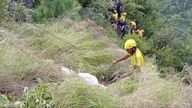 Rescuers pull bodies from the ravine. (Pic: KK Productions via AP)