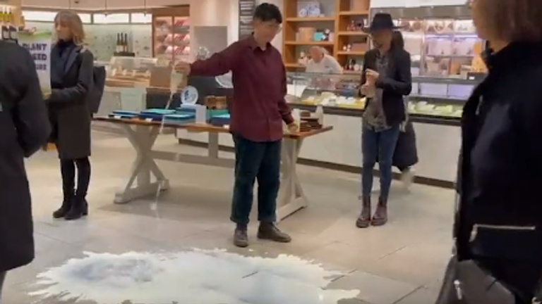An Animal Rebellion supporter pours milk over the floors at Fortnum & Mason