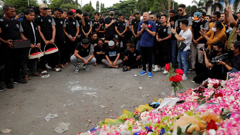 Les joueurs et les officiels du FC Arema prient pour présenter leurs condoléances aux victimes de l'émeute et de la bousculade à la suite d'un match de football entre Arema et Persebaya, devant le stade Kanjuruhan à Malang, province de Java oriental, Indonésie, le 3 octobre 2022. REUTERS/Willy Kurniawan