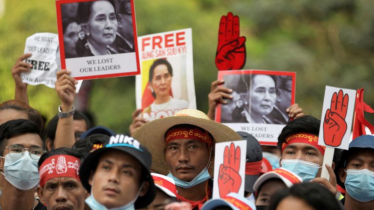 Demonstrators hold signs with pictures of Suu Kyi as they protest the military coup in Yangon