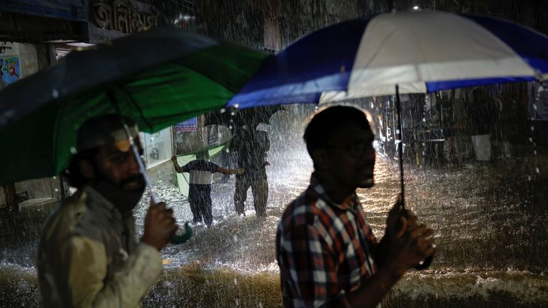 People wade through a flooded street amid continuous rain before Cyclone Sitrang made landfall in Dhaka, Bangladesh October 24, 2022. REUTERS/Mohammad Ponir Hossain