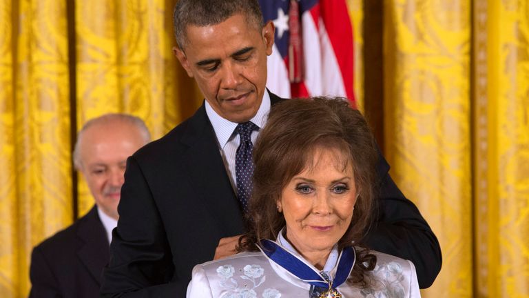 FILE - President Barack Obama awards country music legend Loretta Lynn with the Presidential Medal of Freedom, Wednesday, Nov. 20, 2013, during a ceremony in the East Room of the White House in Washington.  Lynn, the Kentucky coal miner’s daughter who became a pillar of country music, died Tuesday at her home in Hurricane Mills, Tenn. She was 90. (AP Photo/Jacquelyn Martin, File)