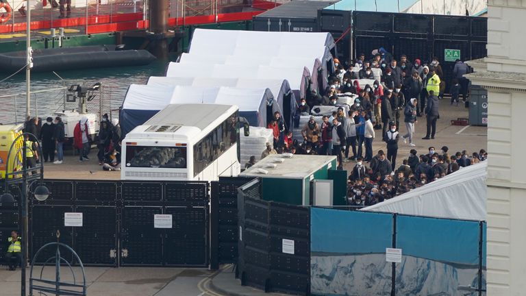 People thought to be migrants wait to be processed at the Border Force compound in Dover, Kent, after being brought from Border Force vessels