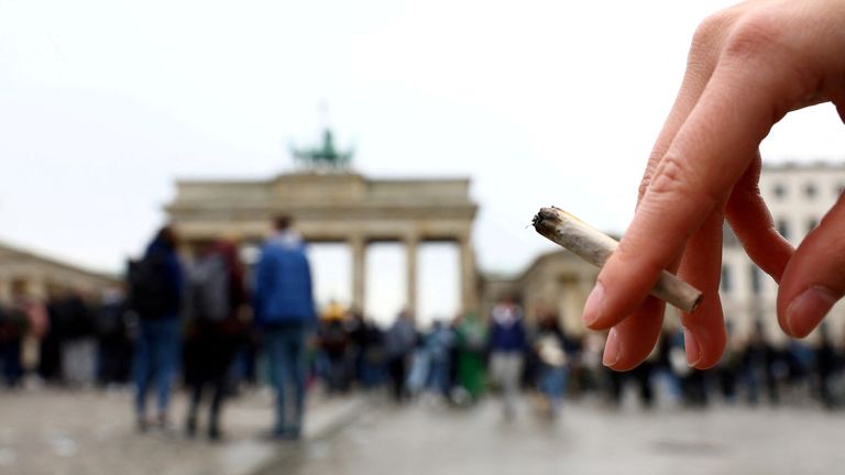 A person holds a joint as activists gather to mark the annual world cannabis day and to protest for legalization of marijuana, in front of the Brandenburg Gate, in Berlin, Germany, April 20, 2022