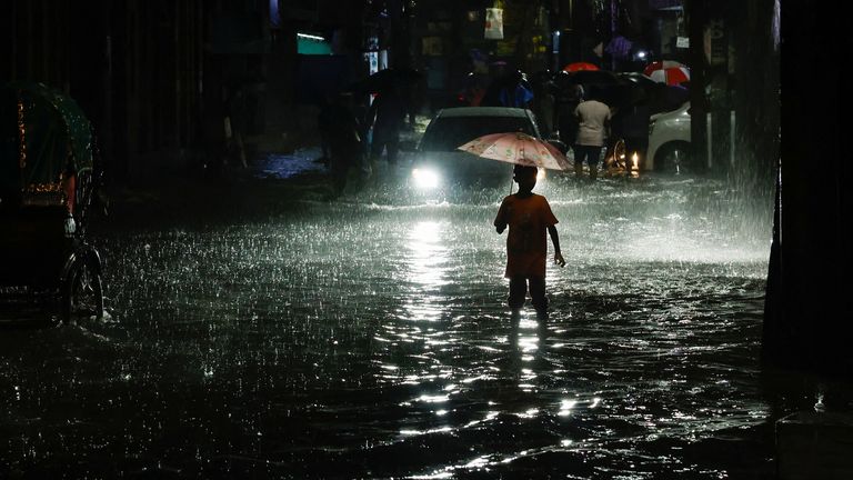 A boy walks through water as streets are flooded due to continuous rain before Cyclone Sitrang makes landfall in Dhaka, Bangladesh October 24, 2022. REUTERS/Mohammad Ponir Hossain