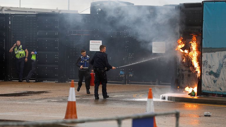 Members of the military and UK Border Force extinguish a fire from a petrol bomb, targeting the Border Force centre in Dover, Britain, October 30, 2022. REUTERS/Peter Nicholls
