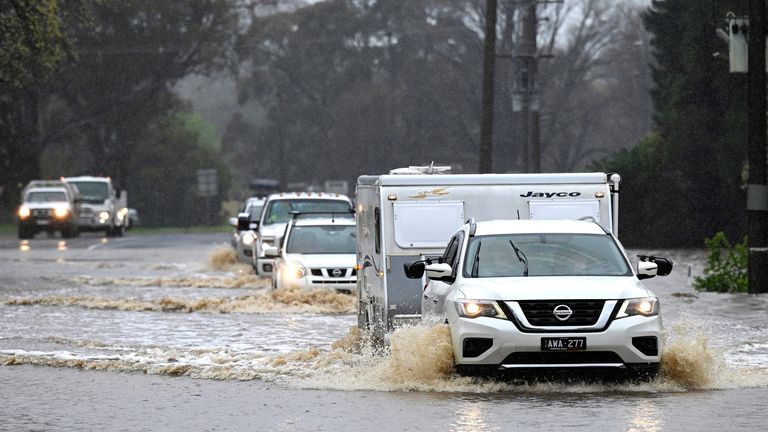 Cars slosh through a flooded road in Heathcote in Australia&#39;s Victoria State, Thursday, Oct. 13, 2022. Rivers across Australia&#39;s most populous states New South Wales and Victoria, as well as the island state of Tasmania were rising dangerously with catchments soaked by months of above-average rainfall. (James Ross/AAP Image via AP)