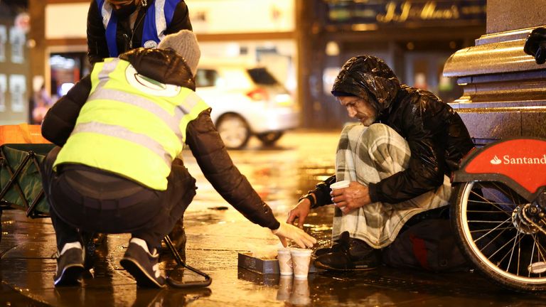 Volunteers working for the Tooting Community Kitchen hand out food donations to a homeless man in Tooting, amid the coronavirus pandemic, South London, Britain, November 14, 2020. Picture taken November 14, 2020. REUTERS/Henry Nicholls
