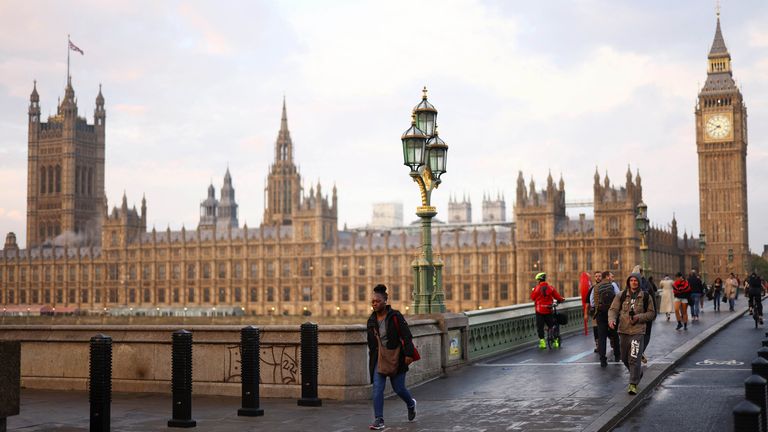 People walk outside the Houses of Parliament during sunrise in London, Britain October 21, 2022. REUTERS/Henry Nicholls