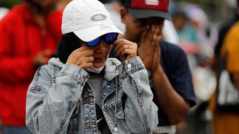 Une femme réagit en présentant ses condoléances aux victimes de l'émeute et de la bousculade à la suite d'un match de football entre Arema et Persebaya, devant le stade Kanjuruhan à Malang, province de Java oriental, Indonésie, le 3 octobre 2022. REUTERS/Willy Kurniawan