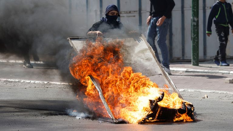 Demonstrators set up a burning barricade during clashes with Israeli forces following a deadly Israeli raid in Nablus, in Hebron in the Israeli-occupied West Bank October 25, 2022. REUTERS/Mussa Qawasma
