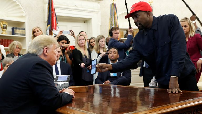 Il rapper Kanye West mostra al presidente Donald Trump una foto sul suo cellulare di quello che ha descritto come un aeroplano a idrogeno che dovrebbe sostituire l'Air Force One durante un incontro nello Studio Ovale alla Casa Bianca a Washington, USA, 11 ottobre 2018. REUTERS /Kevin Lamarque