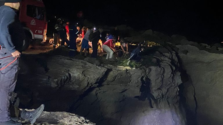 Authorities and local residents save a migrant during a large-scale rescue operation on the island of Kythira, some 225 kilometers (140 miles) south of Athens, early Thursday, Oct. 6, 2022. The operation is underway off a southern Greek island where a sailboat carrying up to 100 migrants sank in high winds. The coast guard said its vessels, private boats and a rescue helicopter were involved in the effort off the coast of the island of Kythira. (Ippolytos Prekas/kythera.news via AP)