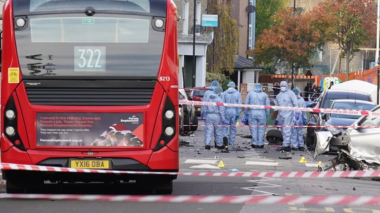 Police officers in forensic suits at the scene on Railton Road in Lambeth, south London, where two men have died after gunshots were heard on Sunday evening. Picture date: Monday October 31, 2022.
