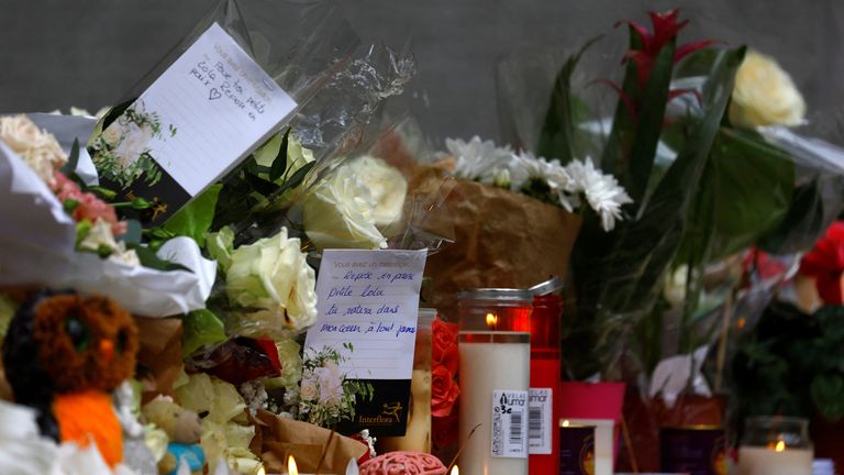 Flowers with a handwritten message that says "Rest in peace little Lola, you will stay in my heart forever." are pictured outside the building where Lola, a 12-year-old schoolgirl, lived who was brutally murdered and whose body was put in a trunk in the 19th arrondissement of Paris, France, October 18, 2022. REUTERS/Gonzalo Fuentes