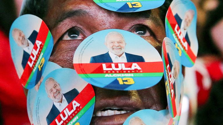 Ένας υποστηρικτής του πρώην προέδρου της Βραζιλίας και υποψηφίου για την προεδρία Λουίς Ινάσιο Λούλα ντα Σίλβα εμφανίζει αφίσες στο πρόσωπό του καθώς συγκεντρώνεται με τους συναδέλφους του την ημέρα του δεύτερου γύρου για τις προεδρικές εκλογές της Βραζιλίας, στη Μπραζίλια της Βραζιλίας, 30 Οκτωβρίου 2022. REUTERS/Φωτογραφία από τον Diego Vara TBX TODAY     