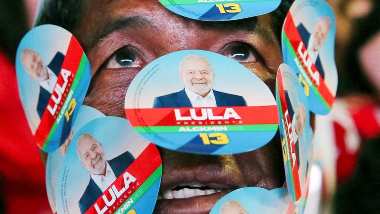 Un partidario del expresidente brasileño y candidato presidencial Luis Inacio Lula da Silva muestra carteles en su rostro mientras se reúne con sus colegas el día de la segunda vuelta de las elecciones presidenciales de Brasil, en Brasilia, Brasil, el 30 de octubre de 2022. REUTERS/Foto por Diego Vara TBX HOY     