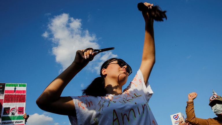 A protestor cuts her hair during a demonstration following the death of Mahsa Amini in Iran, in Istanbul