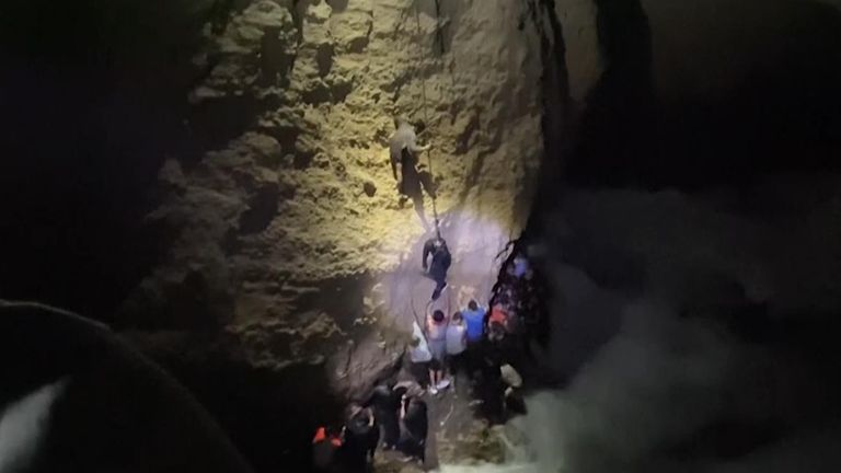 مهاجرون يتسلقون جرفًا شديد الانحدار بعد هجرهم سفينة غارقة في اليونان