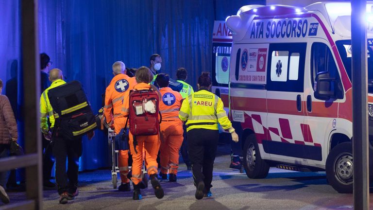 Medics transport an injured person to an ambulance at the scene of an attack in Milan, Italy, Thursday, Oct. 27, 2022. A knife-wielding man stabbed five people inside a shopping center in the south from Milan on Thursday.  (LaPresse via AP)