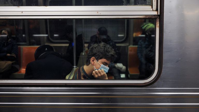 A man wearing a protective face mask sleeps on a subway train in New York City, U.S., May 6, 2022. REUTERS/Shannon Stapleton
