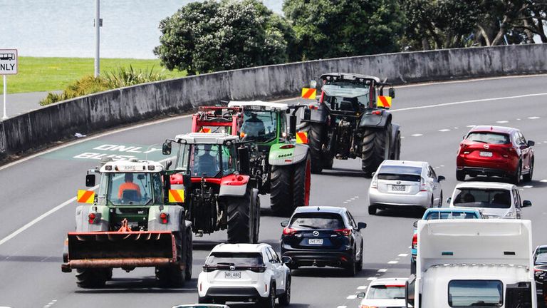 Tractors drive down the southern motorway in central Auckland during a protest on climate change proposals to make New Zealand farmers pay for greenhouse gas emissions, Thursday, Oct. 20, 2022. New Zealand farmers drove their tractors to towns around New Zealand on Thursday in protest at a proposed new tax on cow burps and other farm greenhouse gas emissions. (Dean Purcell/New Zealand Herald via AP)