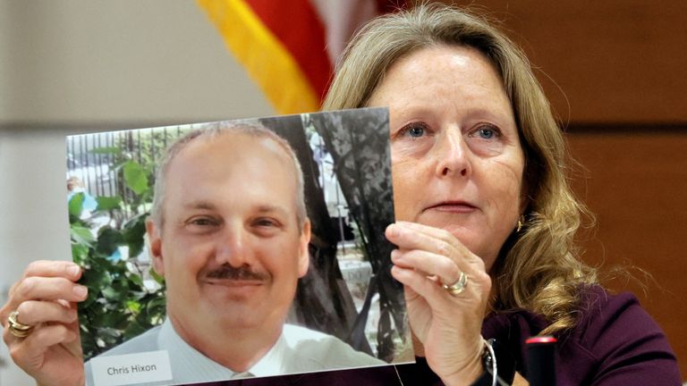 Debbie Hixon holds a photo of her husband, Christopher Hixon