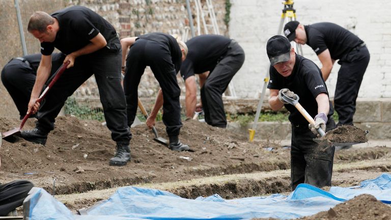Police officers dig in a garden behind the Marine Parade former residence of serial murderer Peter Tobin, in Brighton southern England July 21, 2010. The police are searching in the grounds of a number of properties that Tobin used to live in. REUTERS/Luke MacGregor (BRITAIN - Tags: CRIME LAW POLITICS SOCIETY)