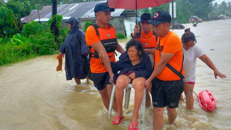 In this photo provided by the Philippine Coast Guard, rescuers evacuate residents from flood waters caused by Tropical Storm Nalgae in Hilongos, Leyte province, Philippines on Friday Oct. 28, 2022. Flash floods and landslides set off by torrential rains left dozens of people dead, including in a hard-hit southern Philippine province, where many villagers are feared missing and buried in a deluge of rainwater, mud, rocks and trees, officials said Saturday. (Philippine Coast Guard via AP)