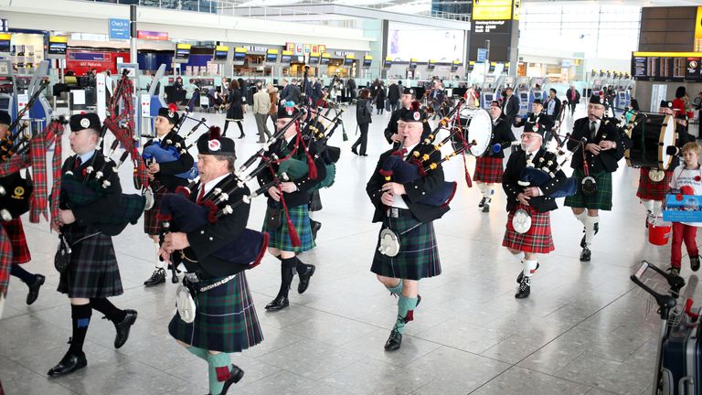 Pipers from the Epping Forest Pipe band performing at terminal 5 at Heathrow airport in London on Royal British Legion&#39;s (RBL) London Poppy Day.