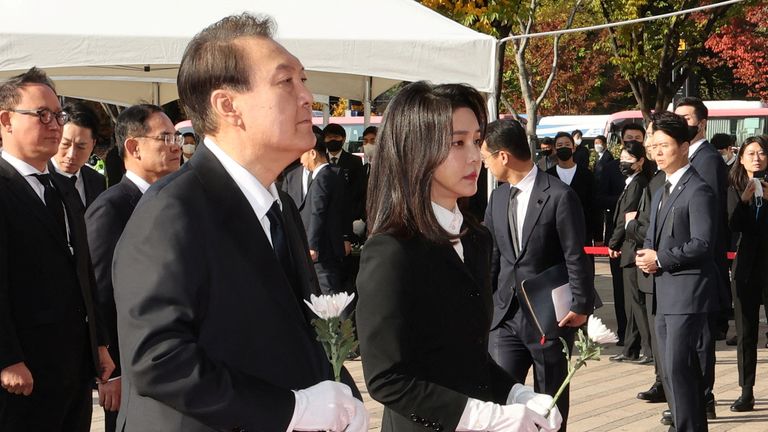 South Korean President Yoon Suk-yeol and his wife Kim Keon-hee hold flowers as they visit a memorial altar for victims of a stampede that happened during Halloween festivities in Seoul, South Korea October 31, 2022. Yonhap via REUTERS ATTENTION EDITORS - THIS IMAGE HAS BEEN SUPPLIED BY A THIRD PARTY. SOUTH KOREA OUT. NO RESALES. NO ARCHIVES.