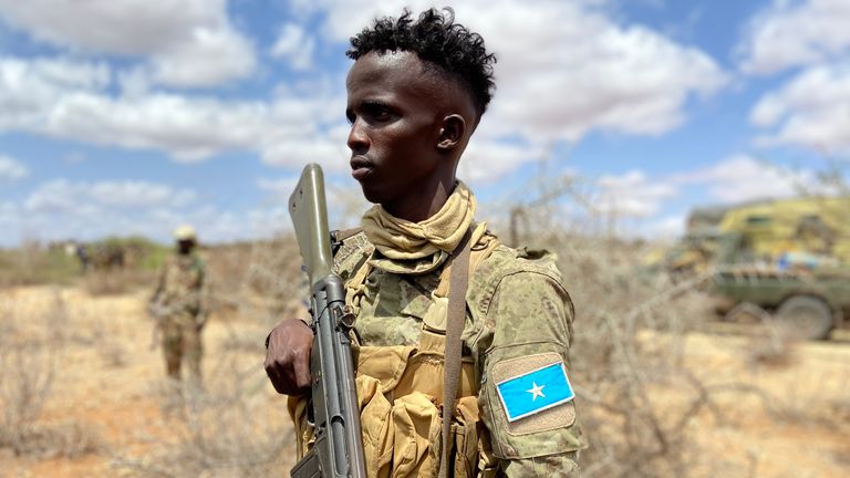 Un soldat al Armatei Naționale Somalie stă de veghe în timp ce rachetele sunt lansate asupra locațiilor Al-Shabaab.