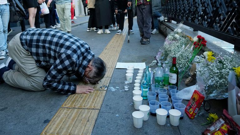 A man bows to pay tribute for victims near the scene of a deadly accident in Seoul, South Korea, Sunday, Oct. 30, 2022, following Saturday night&#39;s Halloween festivities. A mass of mostly young people among tens of thousands who gathered to celebrate Halloween in Seoul became trapped and crushed as the crowd surged into a narrow alley, killing dozens of people and injuring dozens of others in South Korea’s worst disaster in years. (AP Photo/Ahn Young-joon)