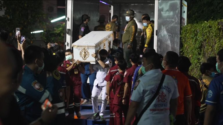Coffin of one of the victims of a mass shooting in Thailand is carried 