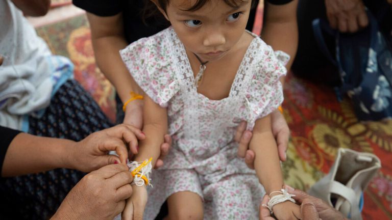 Paweenuch&#39;s relatives tie &#39;soul strings&#39; around her wrist to help restore her spirit Pic: AP 